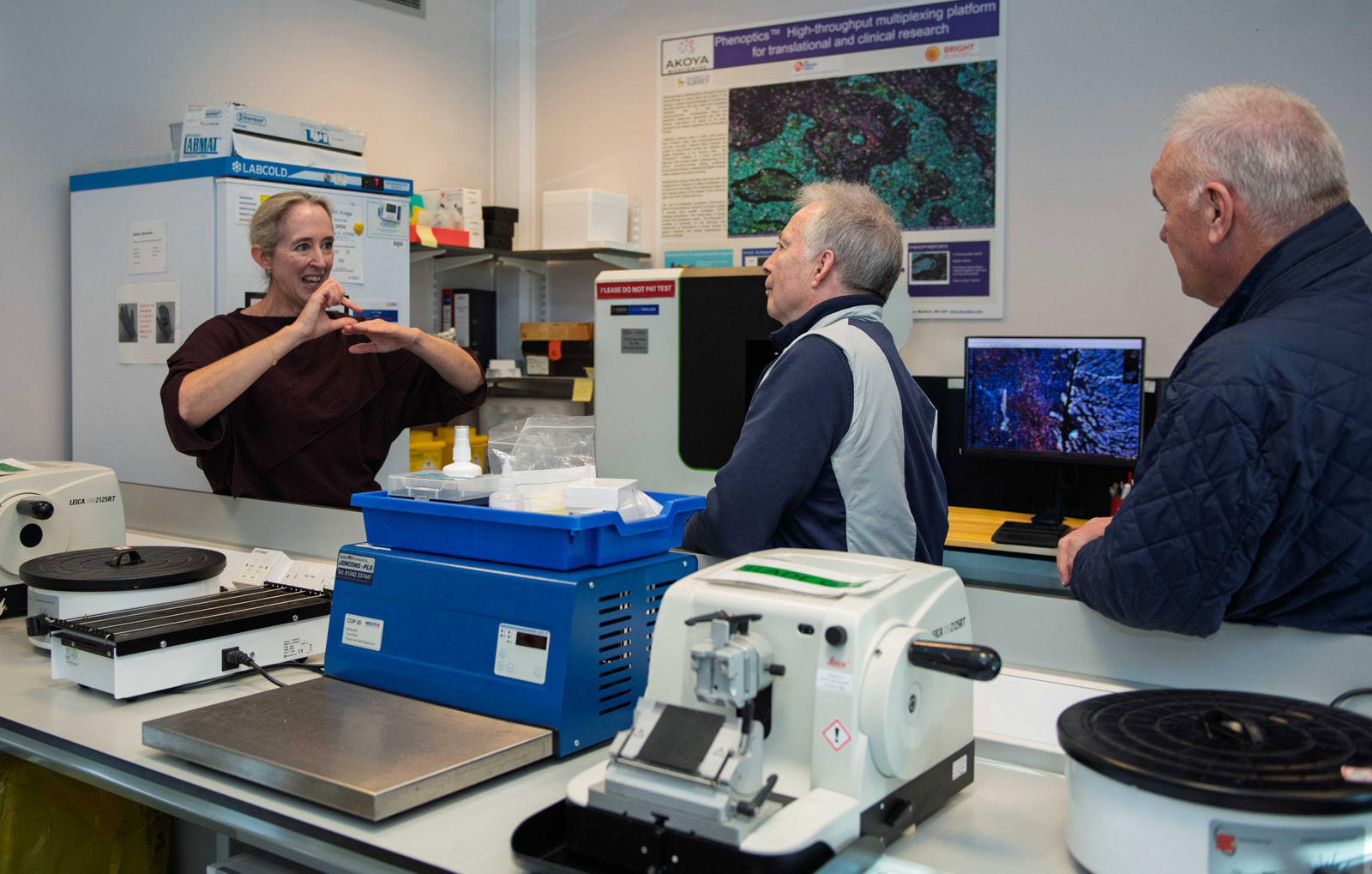 A group of people discussing treatment news in a lab.